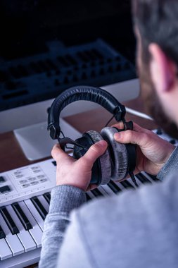 Erkek müzisyen bilgisayar ve klavye, müzisyen işyeri kullanarak müzik yaratır.