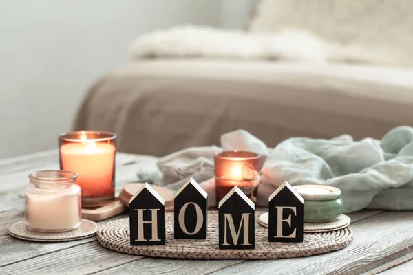 Zavřít dekorativní slovo domů na rozmazaném pozadí se svíčkami. — Stock fotografie