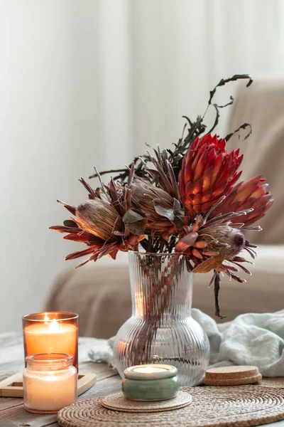 Acogedora composición casera con velas y ramo de protea. —  Fotos de Stock