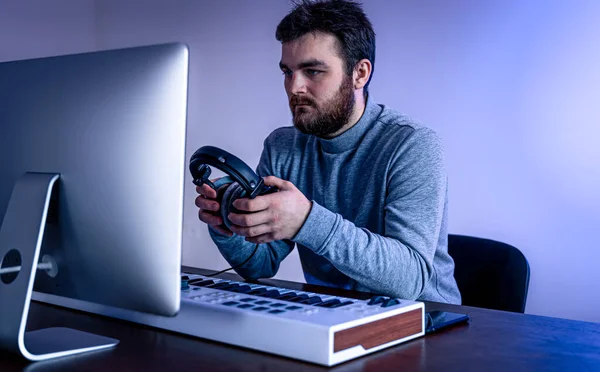 Músico masculino crea música usando computadora y teclado, músico de lugar de trabajo. — Foto de Stock
