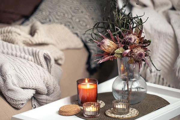 Composição em casa com um buquê de flores de protea e velas. — Fotografia de Stock