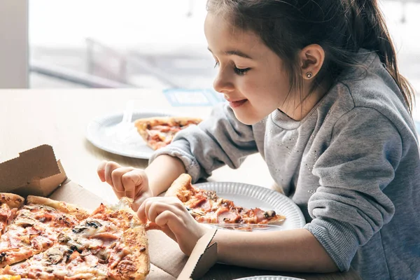 Mutlu küçük kız pizzaya iştahla bakıyor.. — Stok fotoğraf
