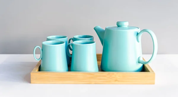 Bule e xícaras, um conjunto de pratos para beber chá em uma bandeja de madeira. — Fotografia de Stock