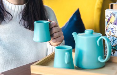 Çaydanlık ve iki mavi bardak masanın üstünde..