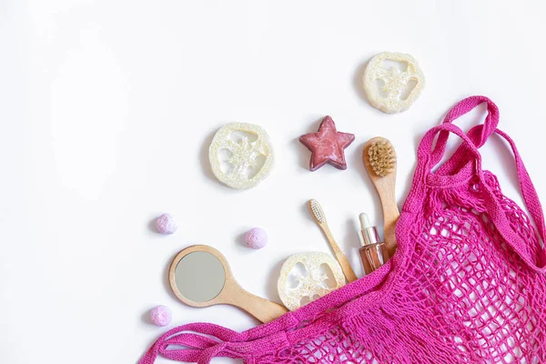 Spa composition with bath accessories in a pink string bag, flat lay. — Stock Photo, Image