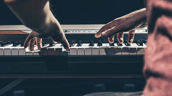 Mãos masculinas tocam as teclas de piano no escuro. — Fotografia de Stock