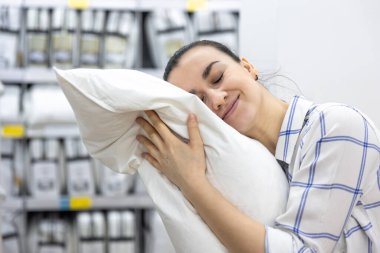 Genç bir kadın ev dekorasyonu mağazasından yastık seçiyor..