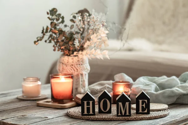 Close up dekorative Wort nach Hause auf verschwommenem Hintergrund mit Kerzen. — Stockfoto