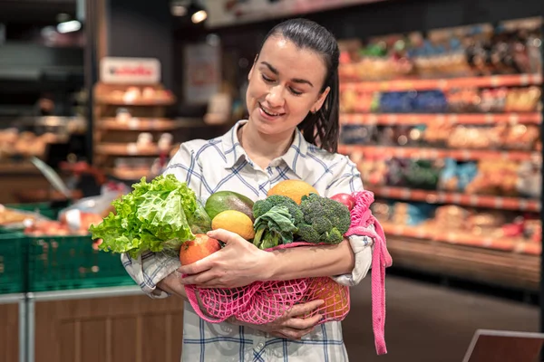 Markette sebze ve meyvelerle alışveriş yapan genç bir kadın.. — Stok fotoğraf