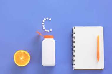 Düz yatış, mavi arka planda haplar, C vitamini konsepti.