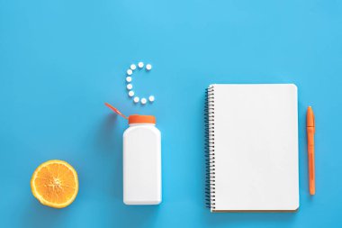 Düz yatış, mavi arka planda haplar, C vitamini konsepti.