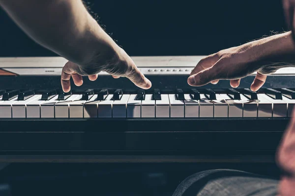 Männliche Hände spielen im Dunkeln auf den Klaviertasten. — Stockfoto