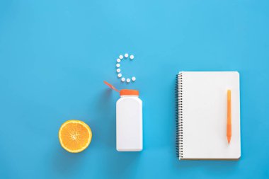 Düz yatış, mavi arka planda haplar, C vitamini konsepti.