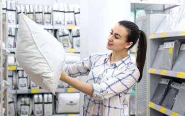 Genç bir kadın ev dekorasyonu mağazasından yastık seçiyor..