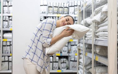 Genç bir kadın ev dekorasyonu mağazasından yastık seçiyor..