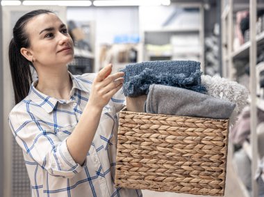 Bir sepet dolusu battaniyesi olan genç bir kadın..