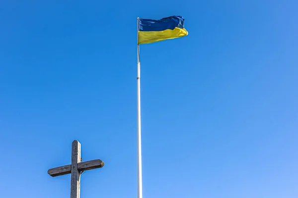 Розп'яття Ісуса Христа і прапор України проти блакитного неба.. — стокове фото