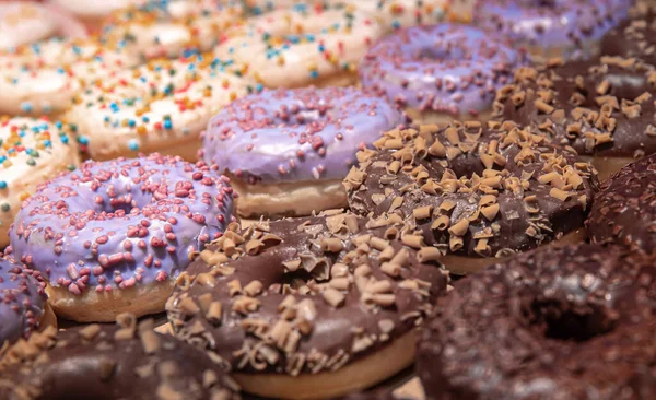 Close up of different donuts with sugar, frosted, glaze, and sprinkles. — Stock Photo, Image