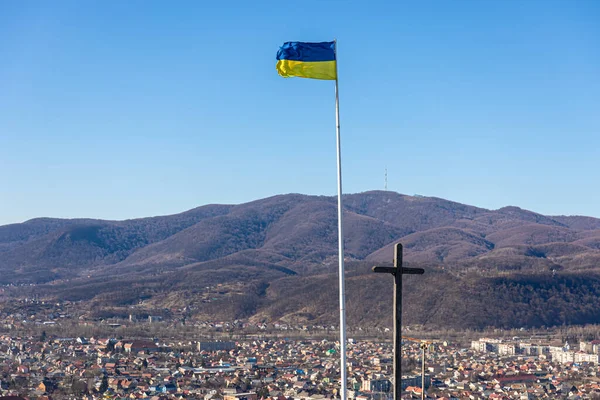 Флаг Украины и крест на фоне гор. — стоковое фото