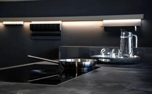 Обсмажування сковороди в інтер'єрі кухні в чорному сучасному стилі . — стокове фото