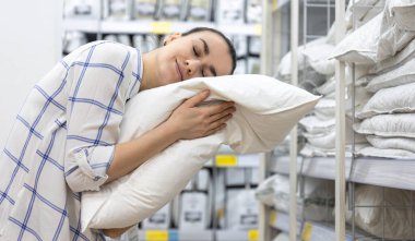 Genç bir kadın ev dekorasyonu mağazasından yastık seçiyor..