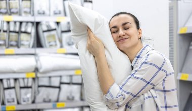 Genç bir kadın ev dekorasyonu mağazasından yastık seçiyor..