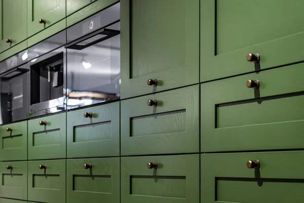 Большой зеленый кухонный шкаф с большим количеством рукояток, крупным планом. — стоковое фото