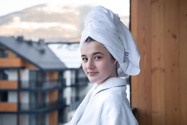 Une jeune femme en peignoir et avec une serviette sur la tête après une douche. — Photo