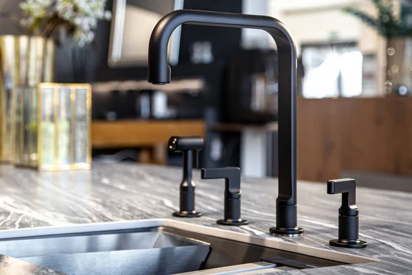 Чорний кран зі сталевою раковиною в стильній сучасній кухні . — стокове фото