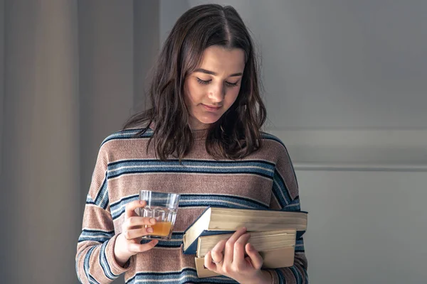 Eine junge Studentin mit Büchern in der Hand im Zimmer. — Stockfoto