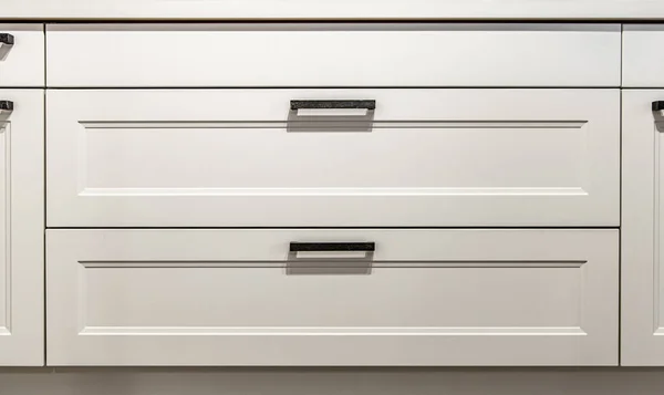 Gabinetes de cocina blancos con tirones de metal o perillas en las puertas. — Foto de Stock