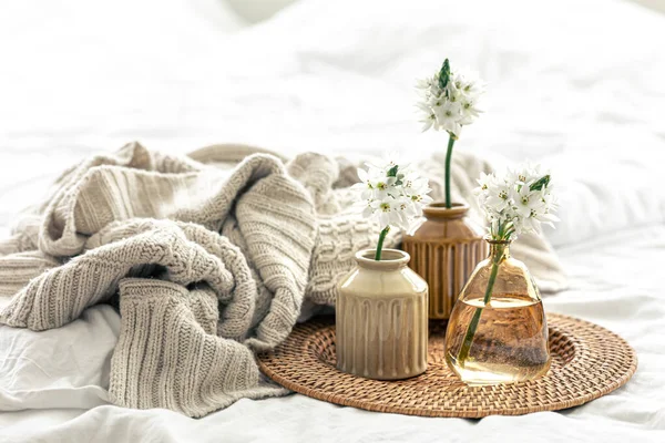 Vazolarda çiçekler ve örülmüş bir element olan ev kompozisyonu.