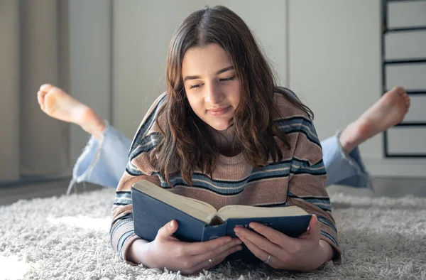 Cute Young Woman Reading Book While Lying Floor Her Room — Foto de Stock