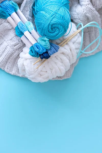 Mavi arkaplanda farklı renk iplikleri, düz yatış, kopyalama alanı.