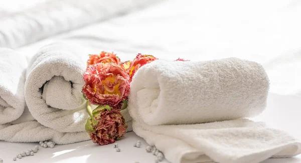 Närbild, vita frotté badlakan och blommor. — Stockfoto