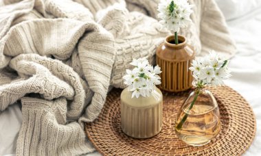 Vazolarda çiçekler ve örülmüş bir element olan ev kompozisyonu.