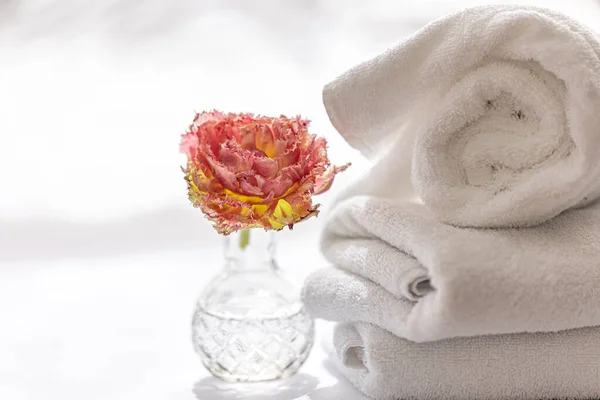 Close-up, white terry bath towels and a flower. — Stock Fotó