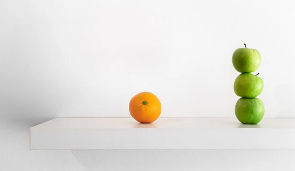 Green apples and orange on a white background close-up. — Foto de Stock