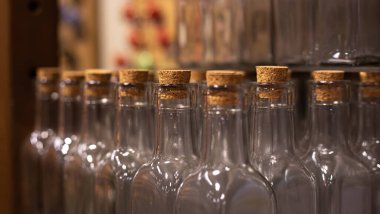 Yakın plan, arka planda tıpaları olan boş cam şişeler..