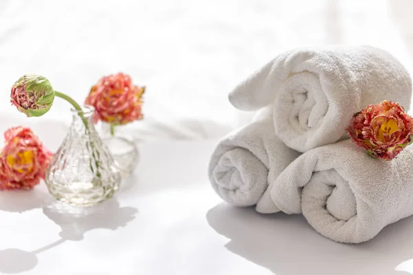 Κοντινές, λευκές πετσέτες μπάνιου terry και λουλούδια. — Φωτογραφία Αρχείου