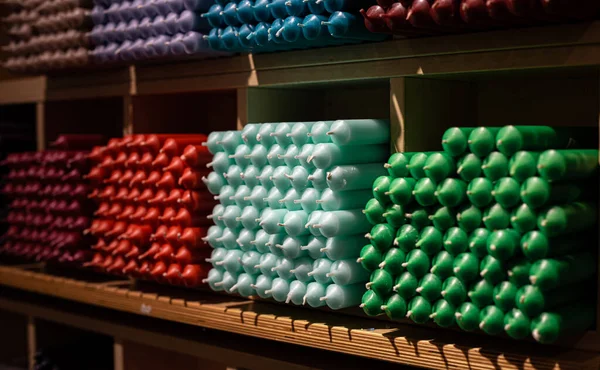 Πολύχρωμα κεριά stick τοποθετημένα στα ράφια και ταξινομημένα κατά χρώμα σε ένα κατάστημα κεριών. — Φωτογραφία Αρχείου