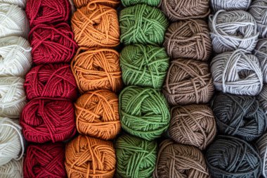 Ahşap masada renkli yün toplar. İplik toplarının çeşitliliği, yukarıdan görünüm.
