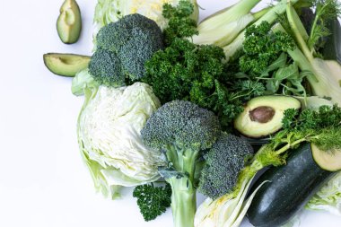 Beyaz arka planda yakın plan, lahana, yeşillik ve avokado..