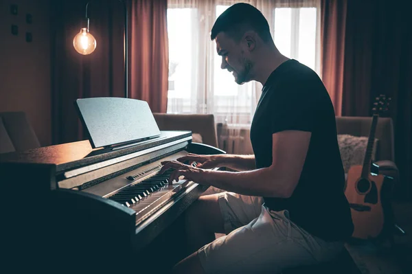 Erkek müzisyen odada elektronik piyano çalar.. — Stok fotoğraf