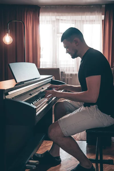 Erkek müzisyen odada elektronik piyano çalar.. — Stok fotoğraf