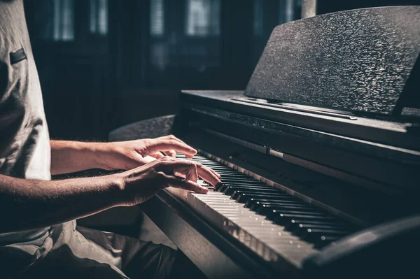 A man plays an electronic piano in a dark room. — 图库照片