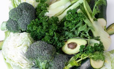 Beyaz arka planda yakın plan, lahana, yeşillik ve avokado..