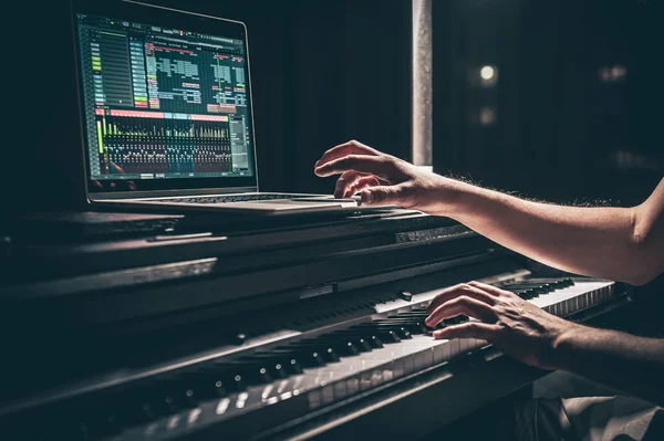 Un hombre compositor, productor, arreglista, compositor, músico manos arreglando la música. — Foto de Stock