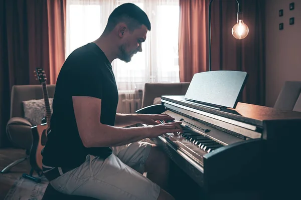 Male musician plays the electronic piano in the room. — 图库照片
