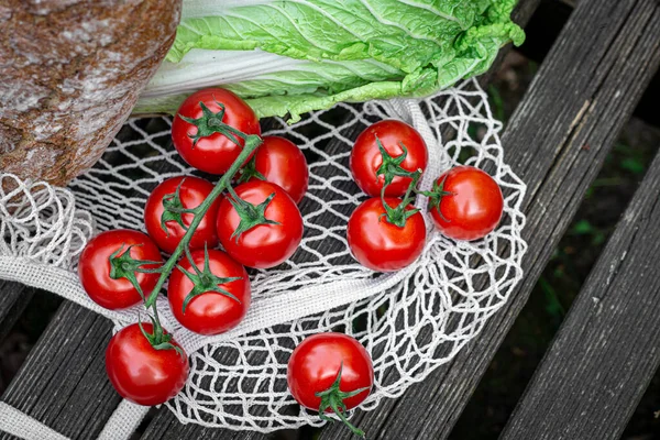 Vegetables and bread in a shopping bag on a wooden surface. — Stock Photo, Image